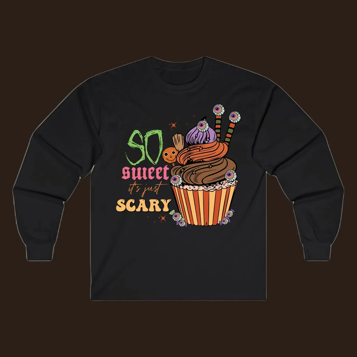 Halloween cupcake illustration with text 'So Sweet It's Just Scary', featuring candy eyeballs and a ghost lollipop.