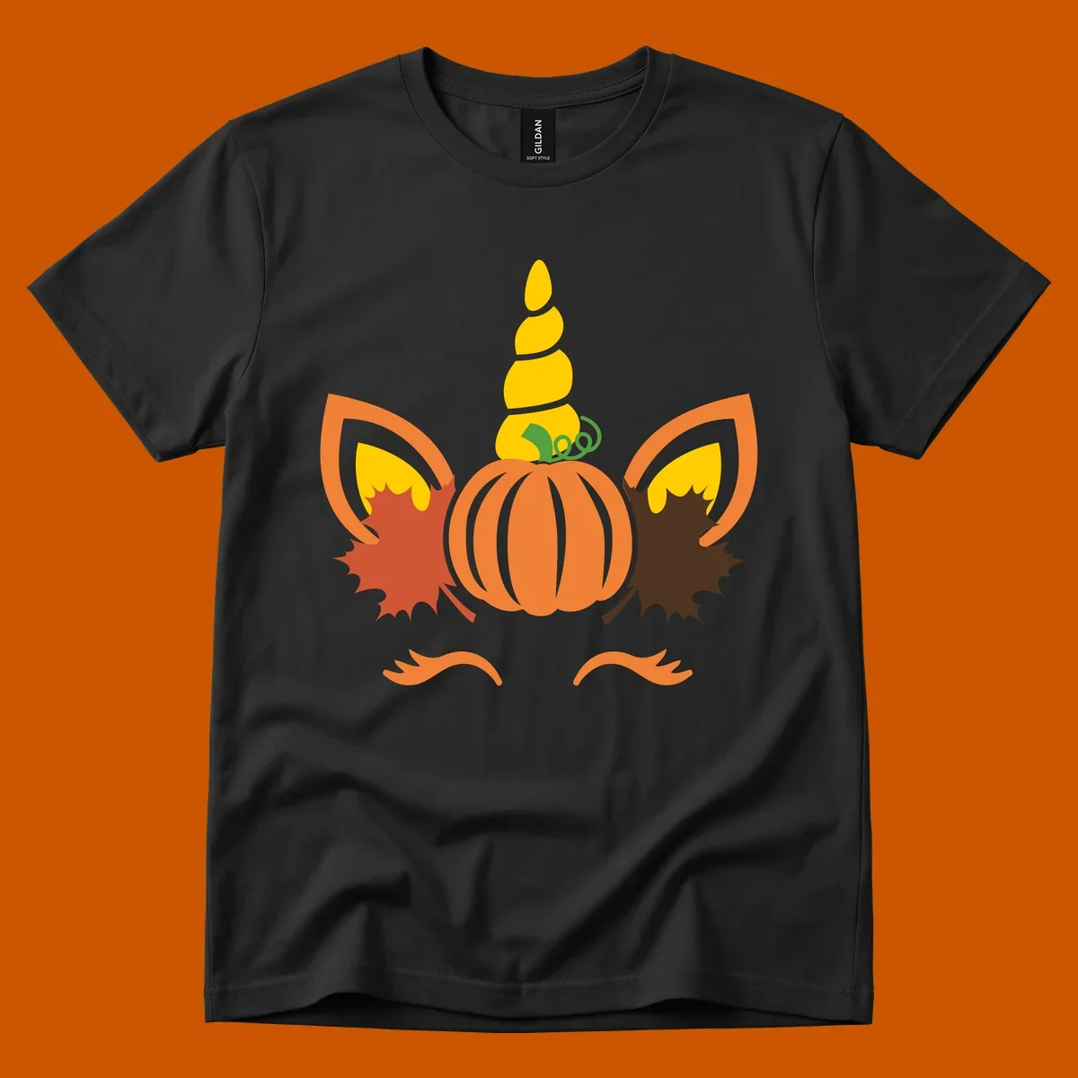 Autumn unicorn pumpkin face with fall leaves graphic.