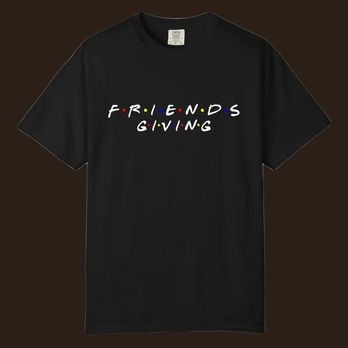 Friendsgiving typography design in white with red, yellow, and blue dots.