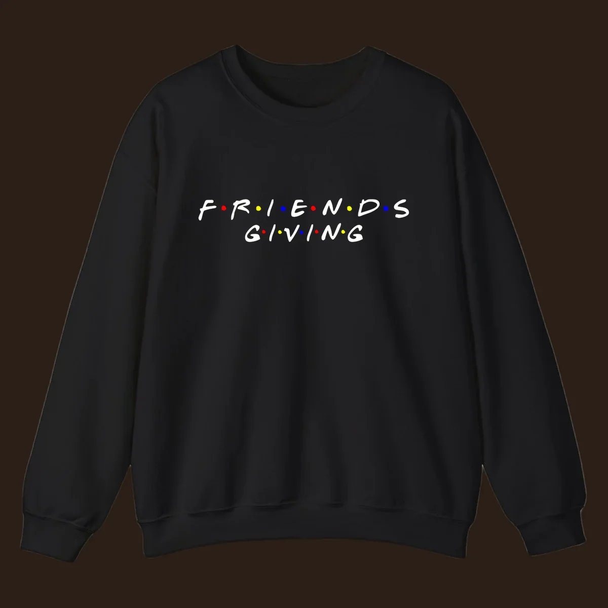 Friendsgiving typography design in white with red, yellow, and blue dots.