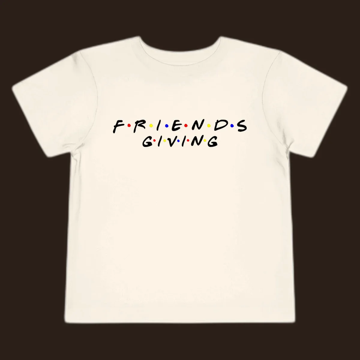 Friendsgiving typography design in white with red, yellow, and blue dots.