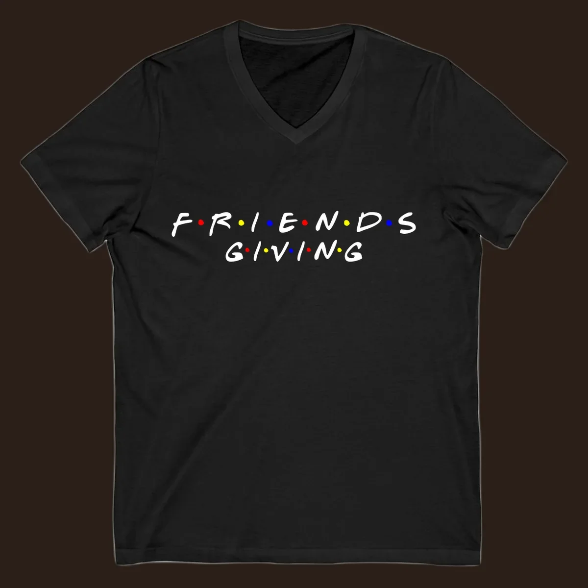 Friendsgiving typography design in white with red, yellow, and blue dots.