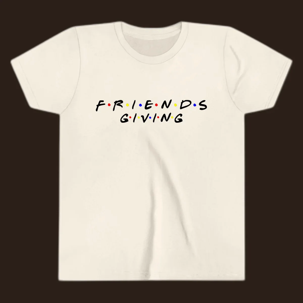 Friendsgiving typography design in white with red, yellow, and blue dots.
