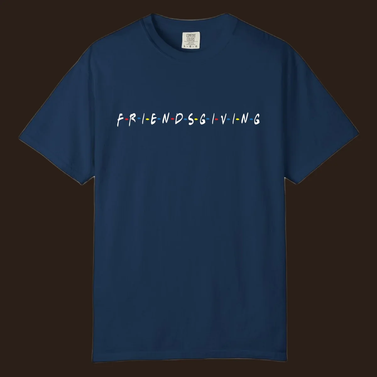 Friendsgiving typography design with white letters and colored dots on a black background.