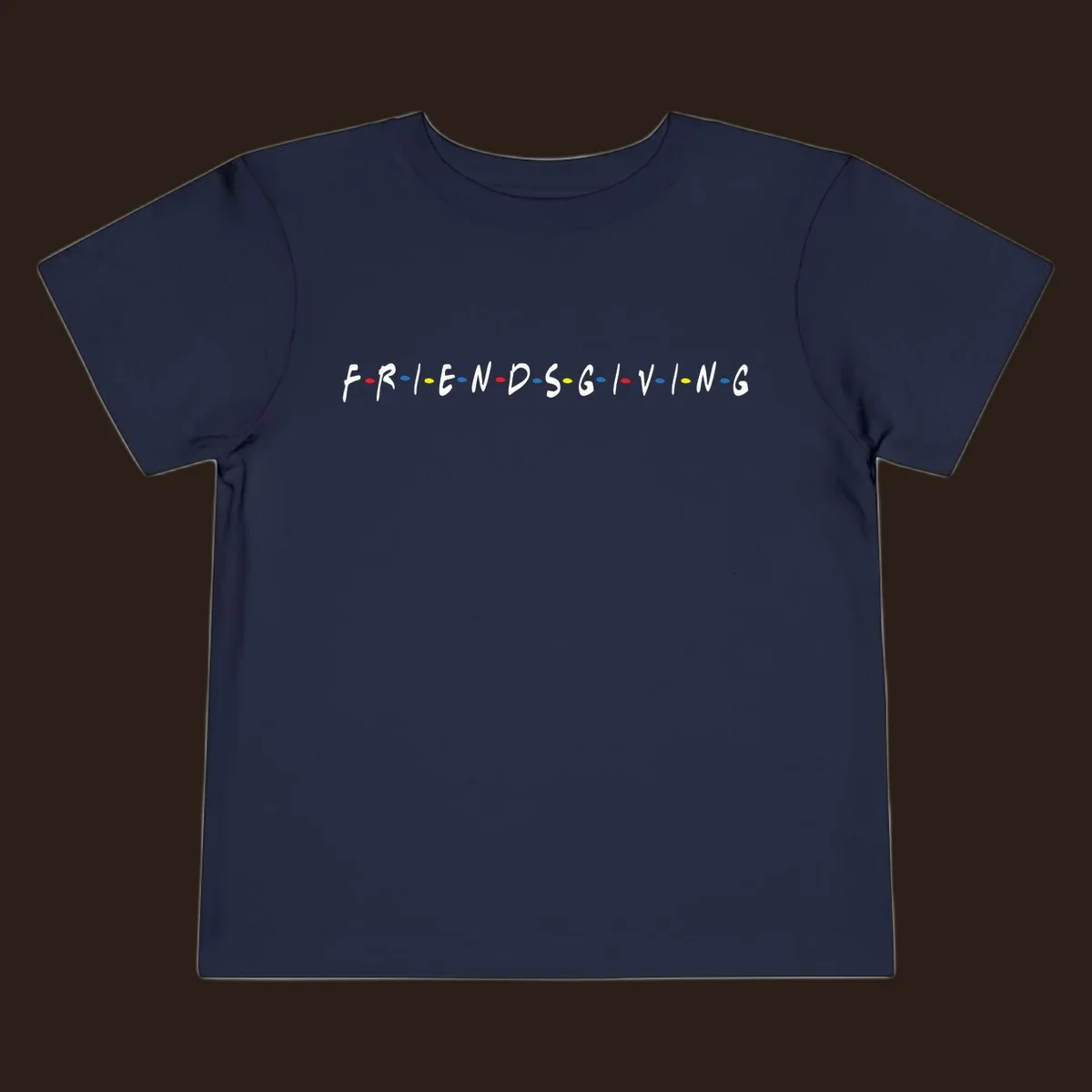 Friendsgiving typography design with white letters and colored dots on a black background.