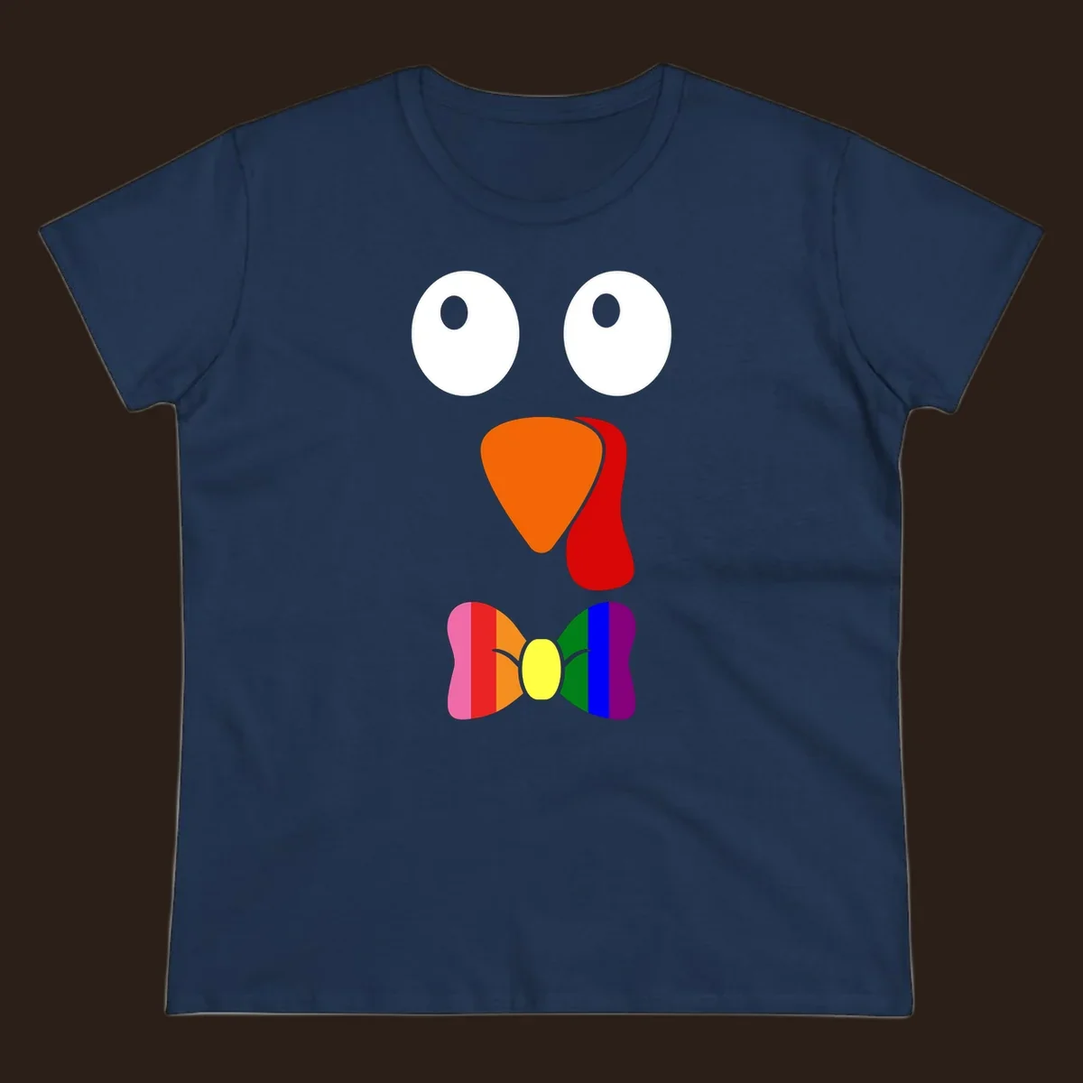 Cartoon turkey face with rainbow bowtie, featuring large eyes, orange beak, and red wattle. Thanksgiving holiday graphic.