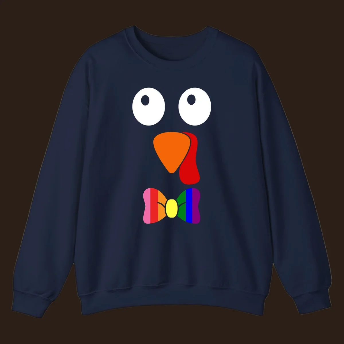 Cartoon turkey face with rainbow bowtie, featuring large eyes, orange beak, and red wattle. Thanksgiving holiday graphic.