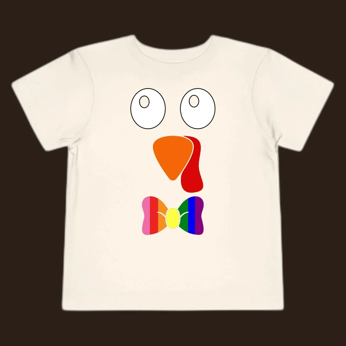 Cartoon turkey face with rainbow bowtie, featuring large eyes, orange beak, and red wattle. Thanksgiving holiday graphic.