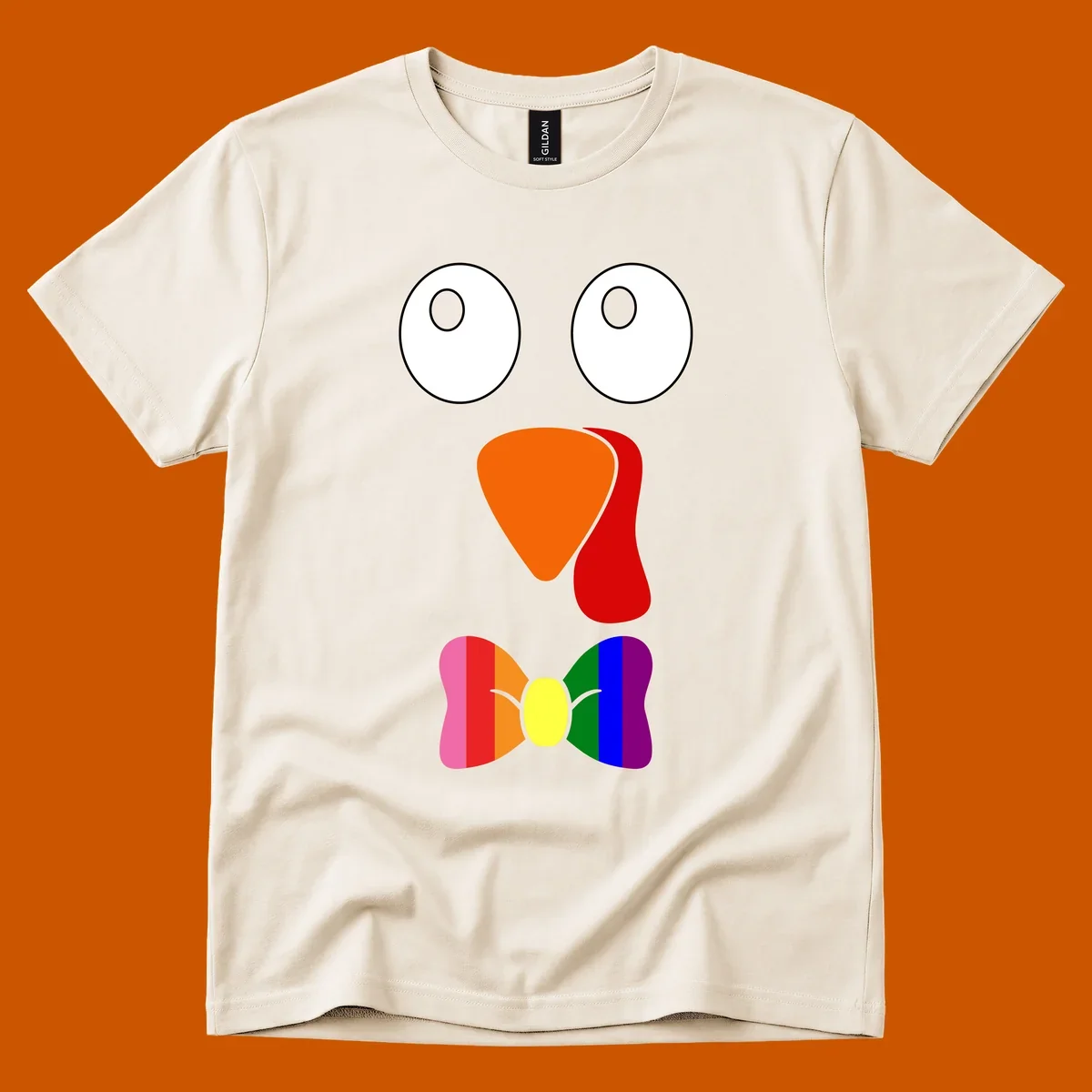Cartoon turkey face with rainbow bowtie, featuring large eyes, orange beak, and red wattle. Thanksgiving holiday graphic.