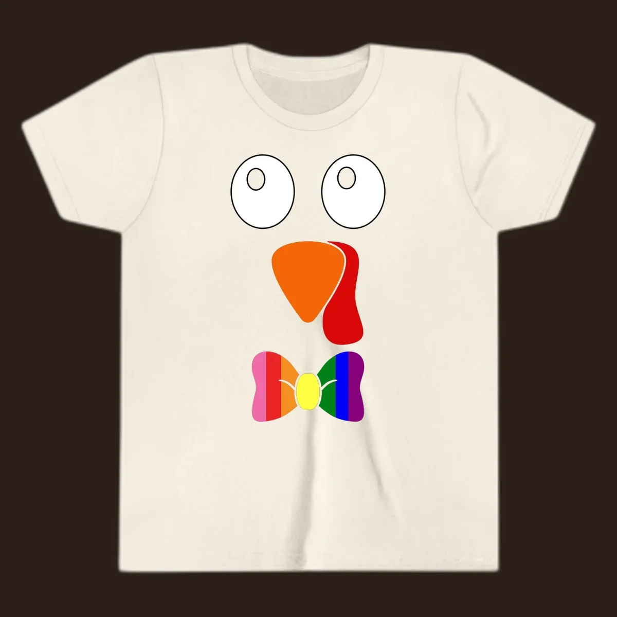 Cartoon turkey face with rainbow bowtie, featuring large eyes, orange beak, and red wattle. Thanksgiving holiday graphic.