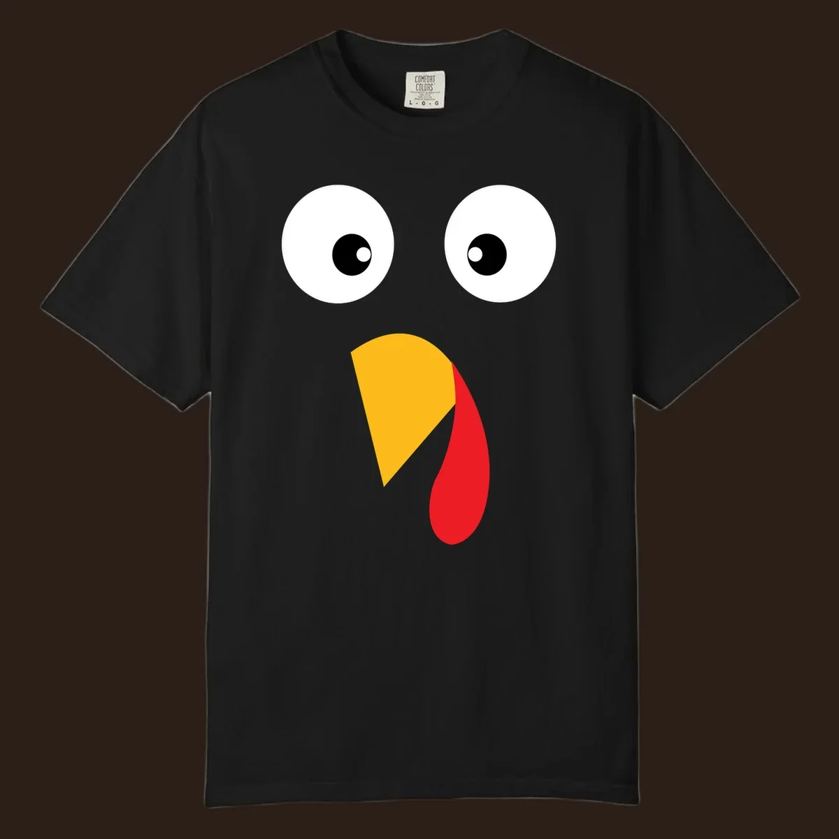 Googly eyed turkey face illustration with yellow beak and red wattle on black background.