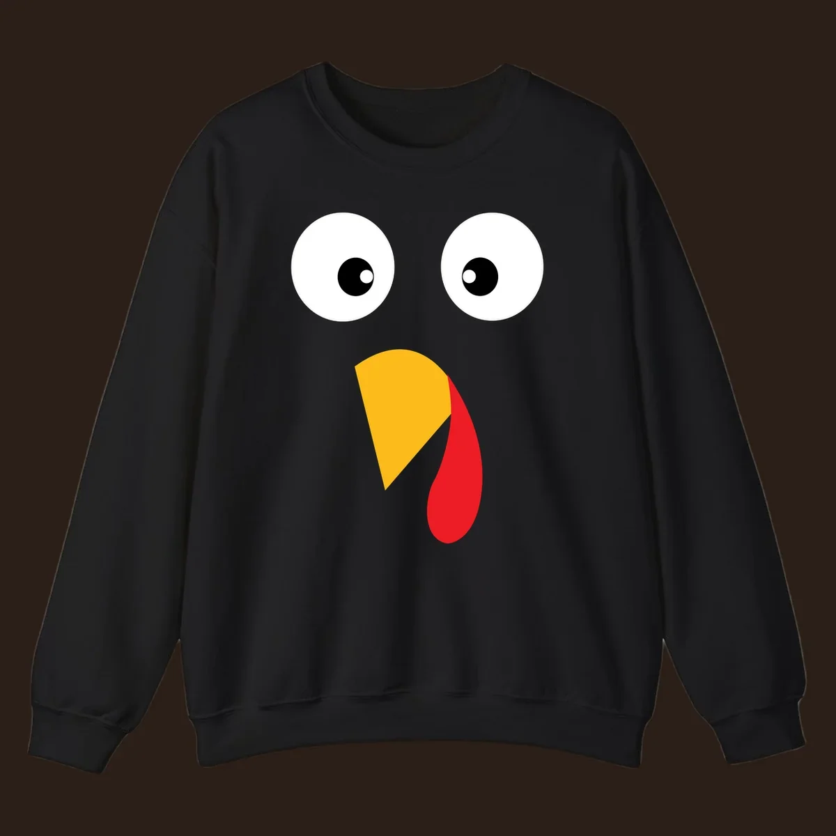 Googly eyed turkey face illustration with yellow beak and red wattle on black background.