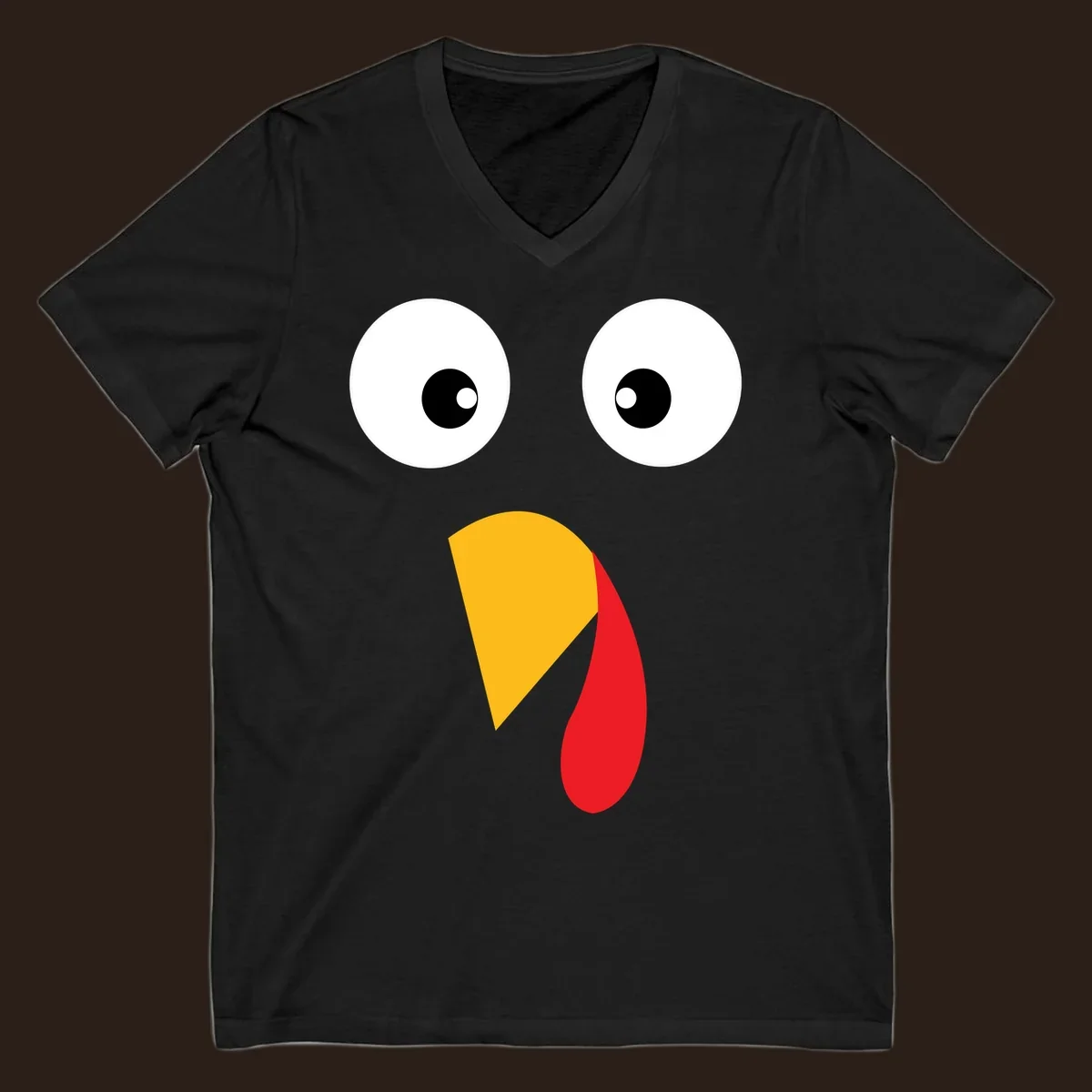 Googly eyed turkey face illustration with yellow beak and red wattle on black background.