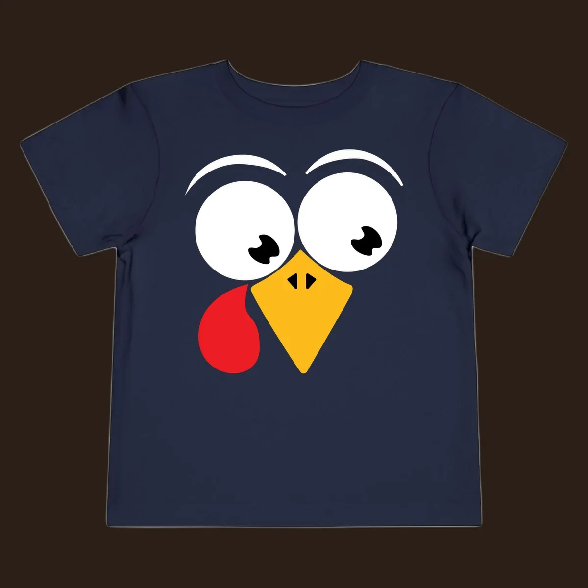 Googly eyed turkey face with yellow beak and red wattle on black background.