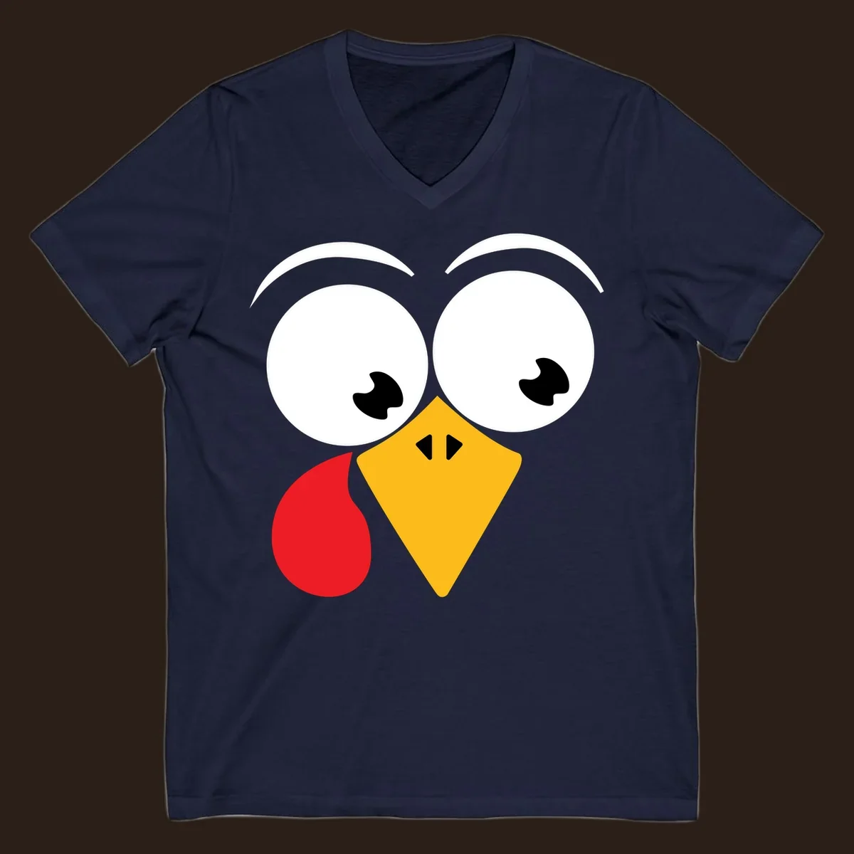 Googly eyed turkey face with yellow beak and red wattle on black background.