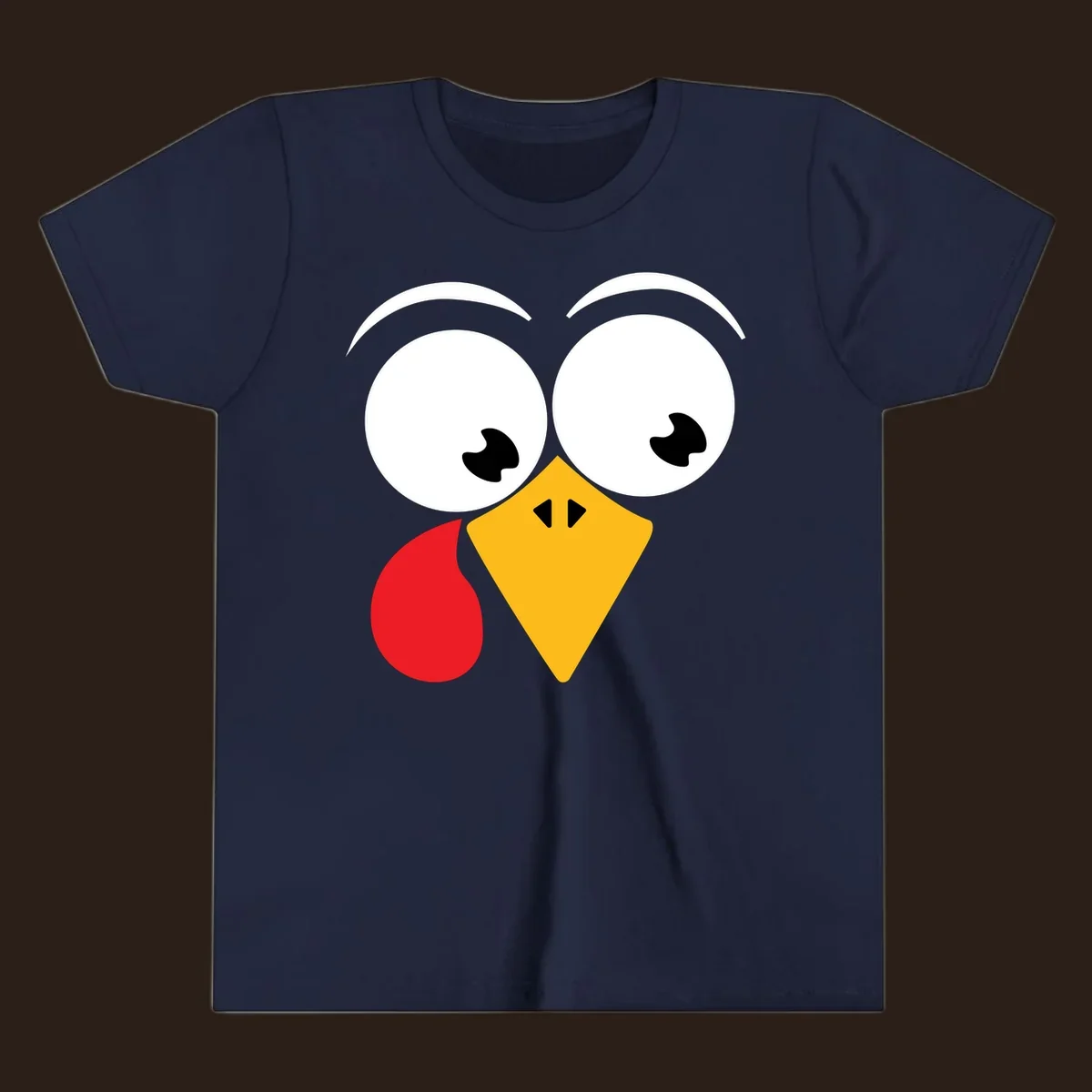 Googly eyed turkey face with yellow beak and red wattle on black background.