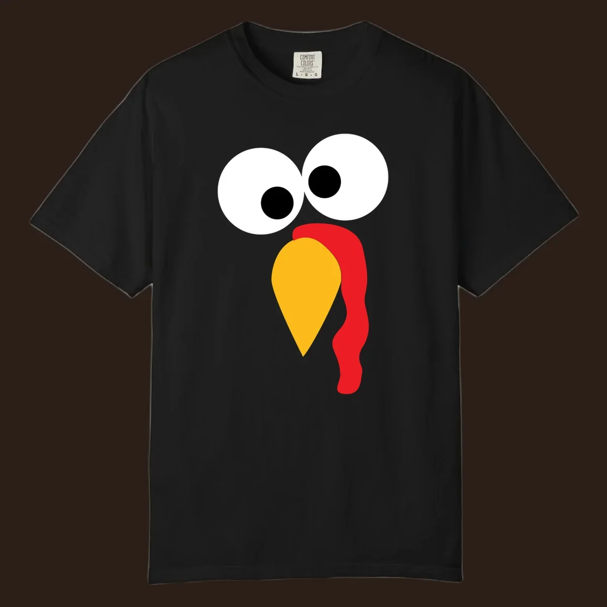 Googly-eyed turkey face illustration with yellow beak and red wattle.