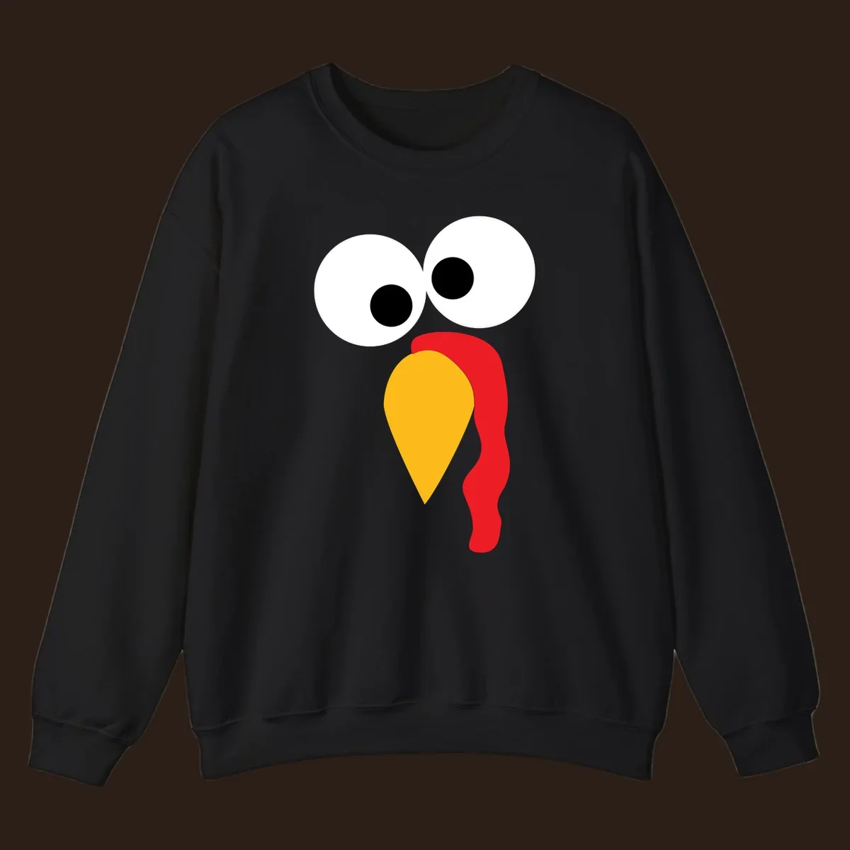 Googly-eyed turkey face illustration with yellow beak and red wattle.