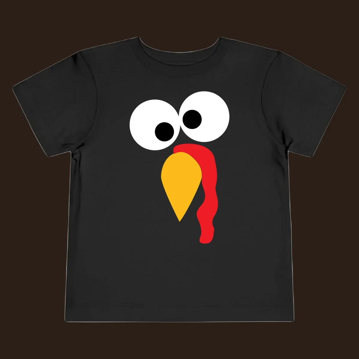 Googly-eyed turkey face illustration with yellow beak and red wattle.