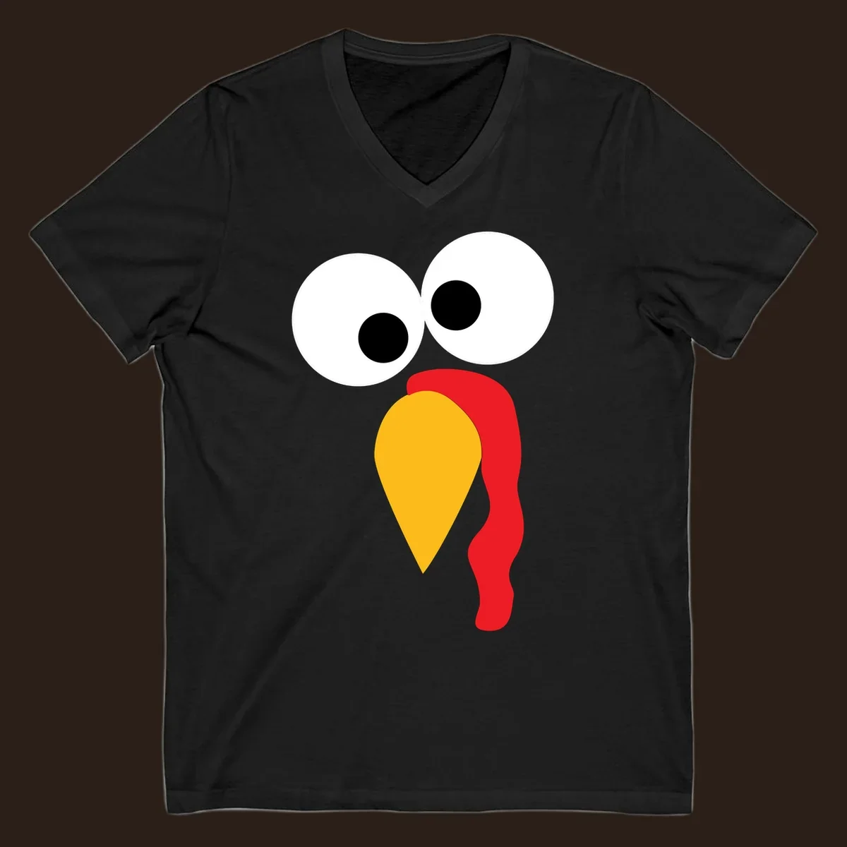 Googly-eyed turkey face illustration with yellow beak and red wattle.