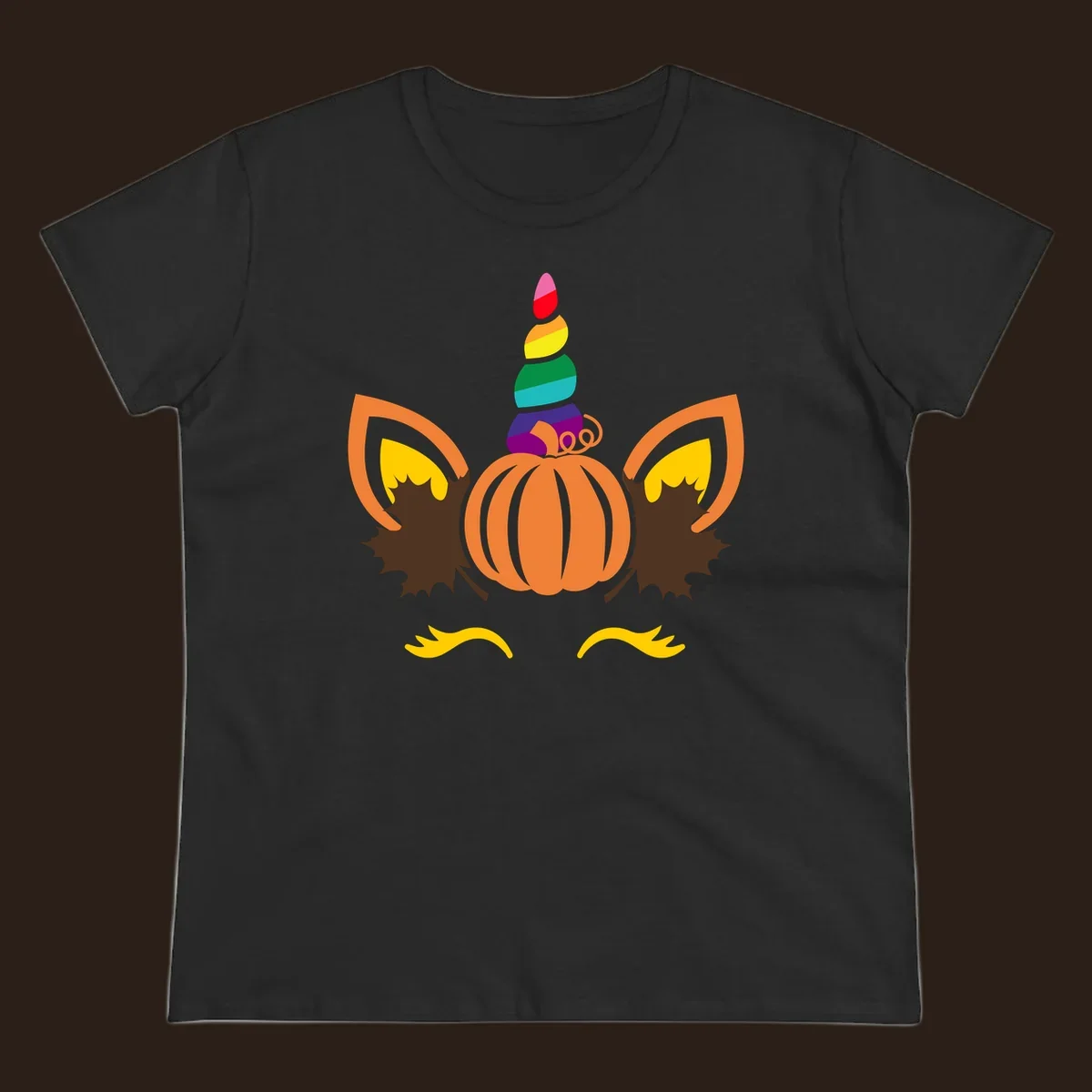 Illustration of a unicorn face made from a pumpkin with a rainbow horn and autumn leaves, on a black background.
