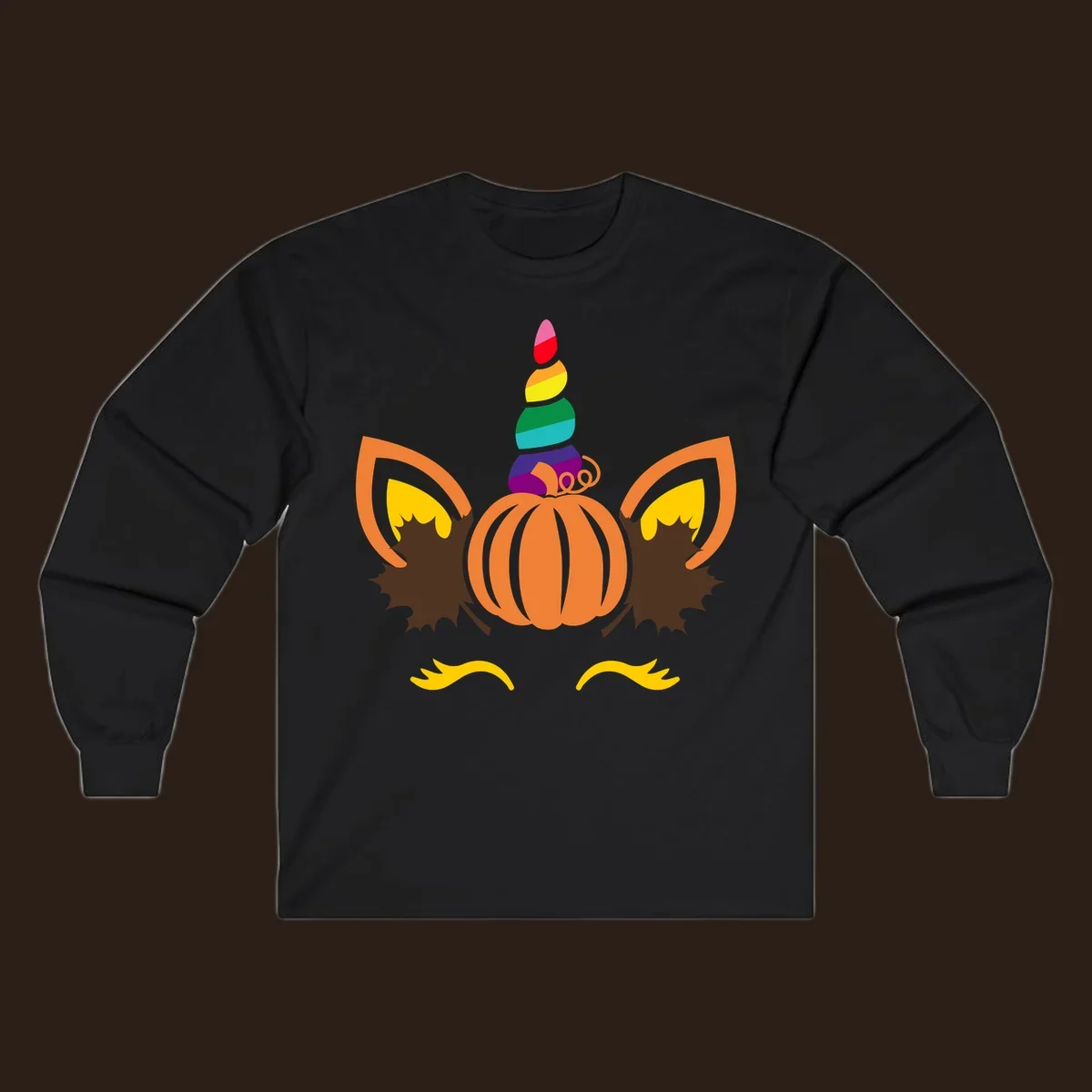 Illustration of a unicorn face made from a pumpkin with a rainbow horn and autumn leaves, on a black background.
