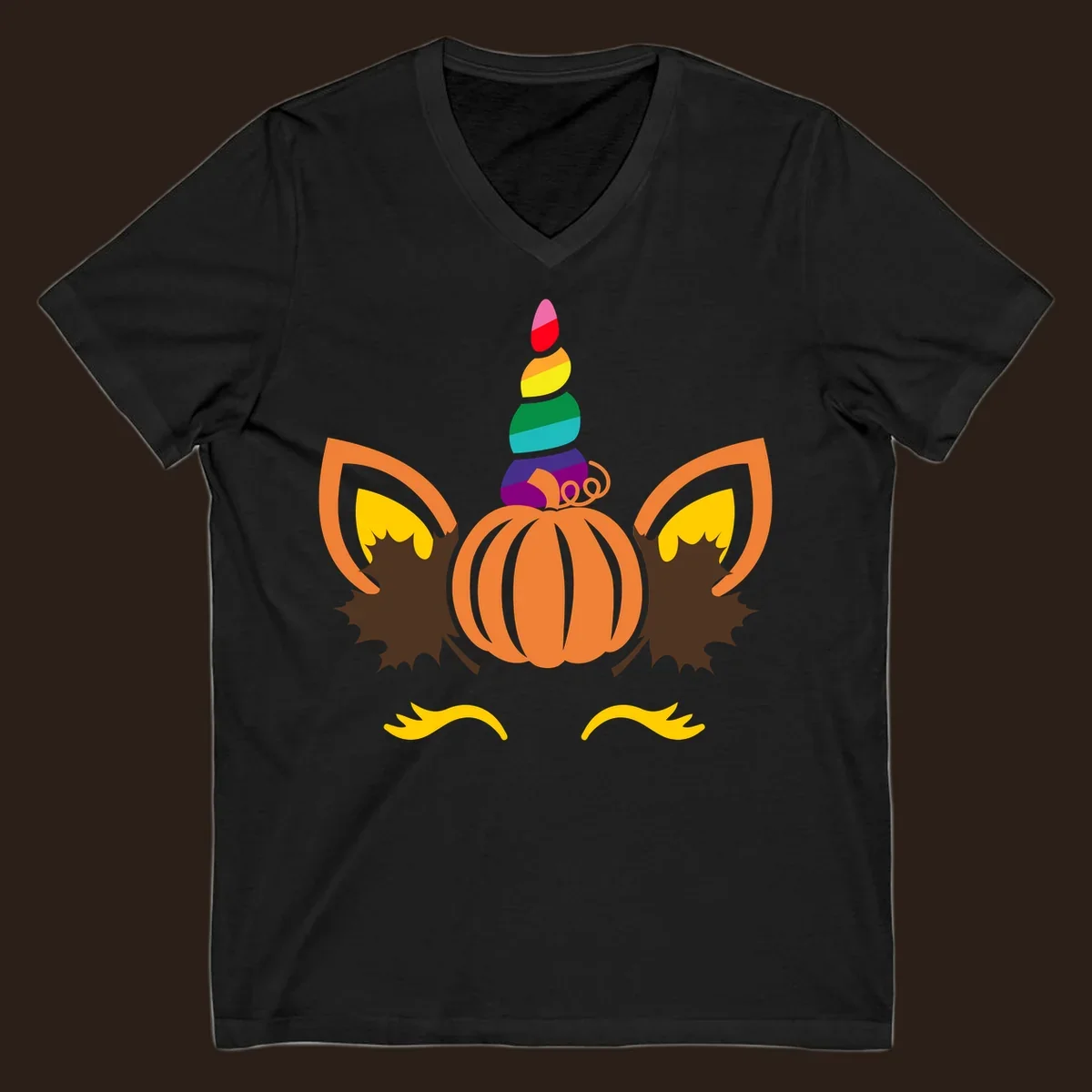 Illustration of a unicorn face made from a pumpkin with a rainbow horn and autumn leaves, on a black background.