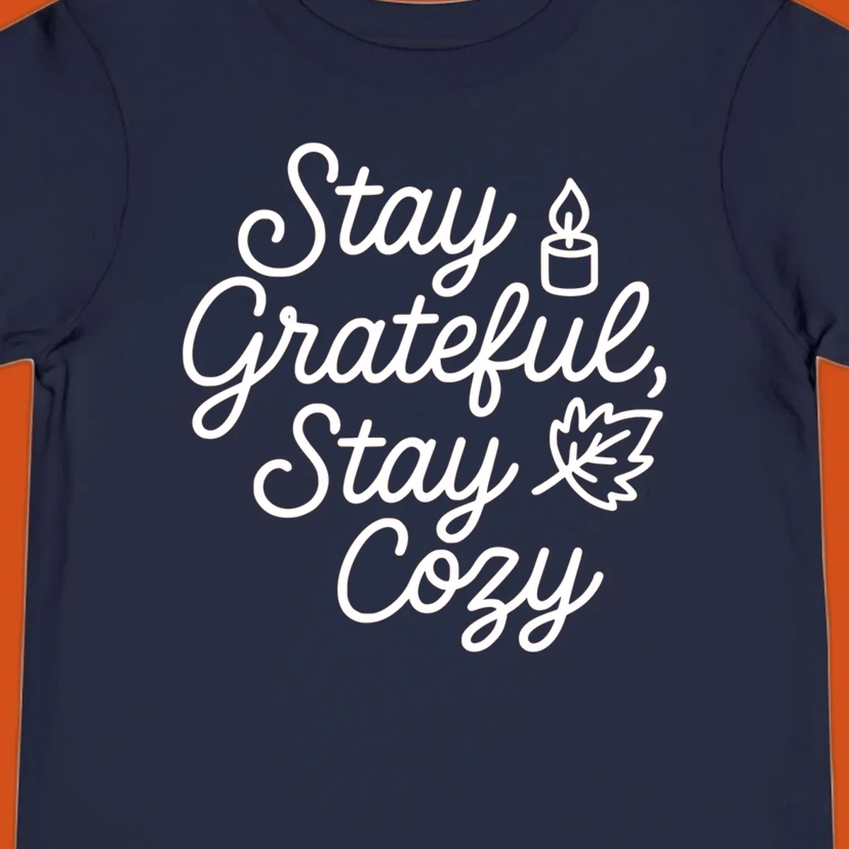 Text design with 'Stay Grateful, Stay Cozy' phrase, candle, and leaf for grateful-cozy-fall theme.