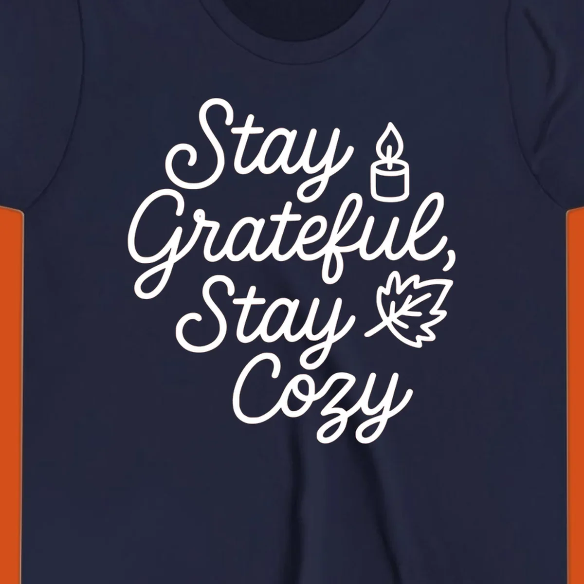 Text design with 'Stay Grateful, Stay Cozy' phrase, candle, and leaf for grateful-cozy-fall theme.