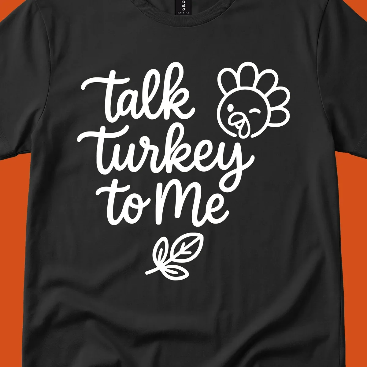 Talk Turkey To Me Thanksgiving phrase with cartoon turkey and leaf illustration.