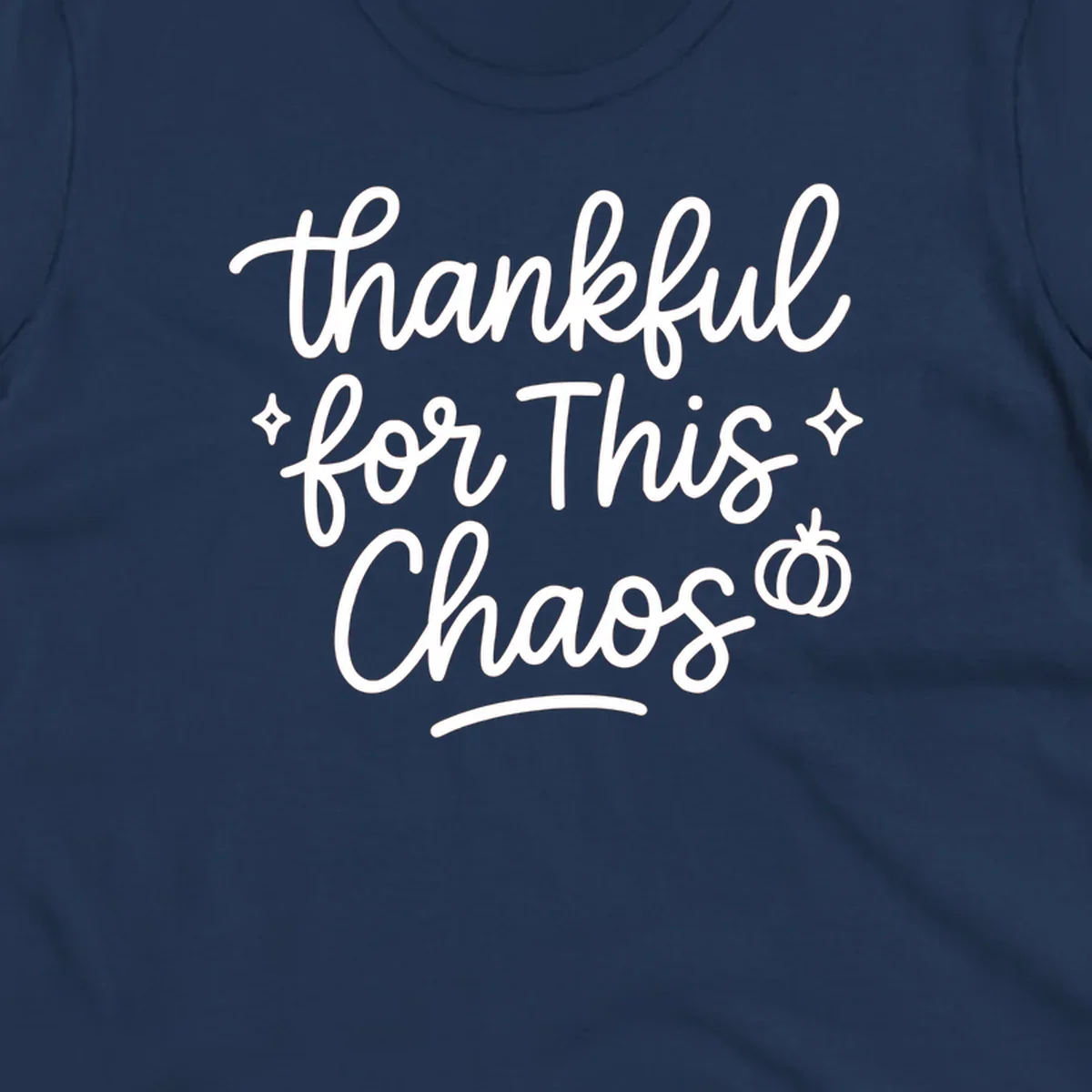 White script text 'thankful for This Chaos' with sparkles and a pumpkin on a black background.