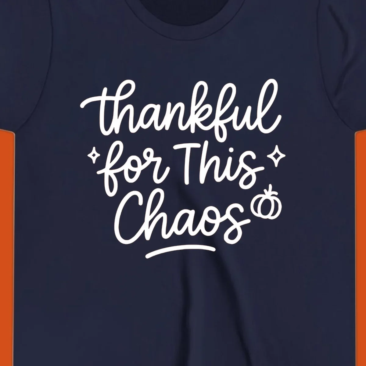 White script text 'thankful for This Chaos' with sparkles and a pumpkin on a black background.