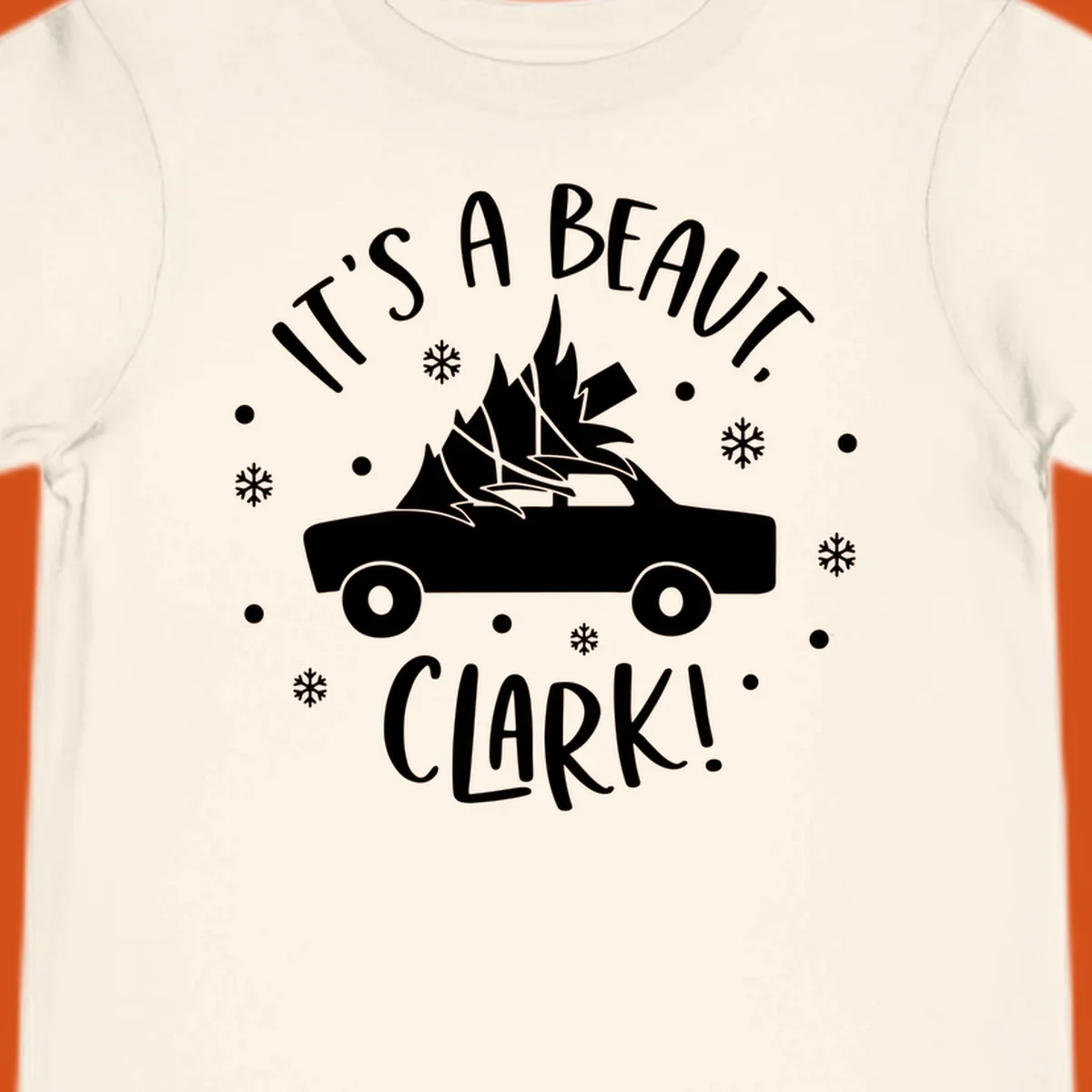 White silhouette of a car with a Christmas tree on top, and text 'IT'S A BEAUT, CLARK!'