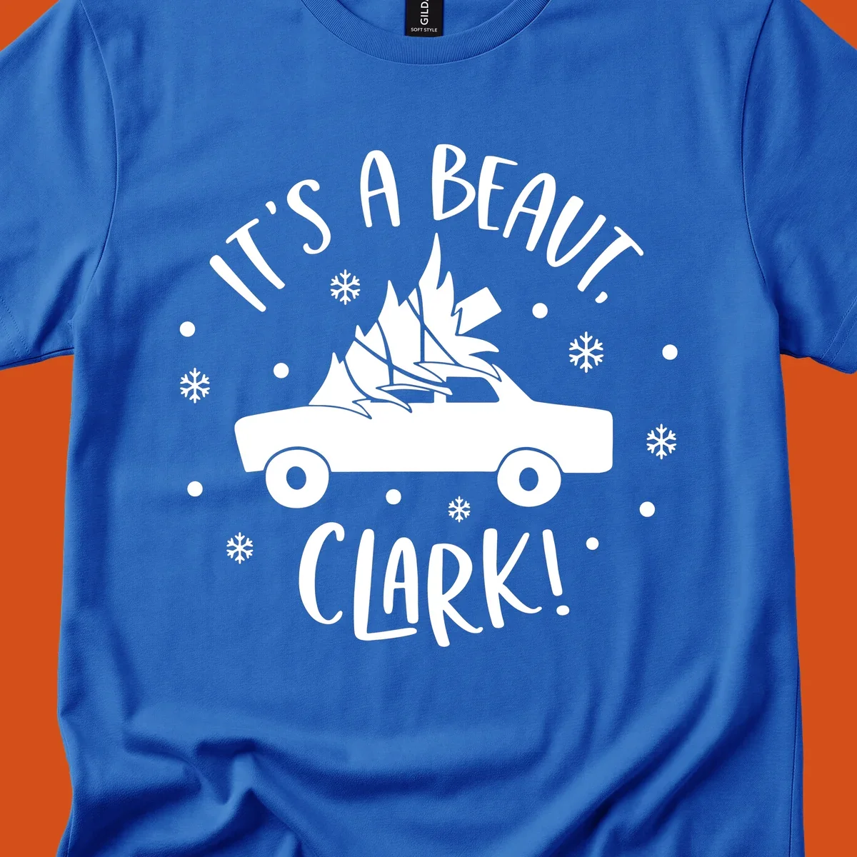 White silhouette of a car with a Christmas tree on top, and text 'IT'S A BEAUT, CLARK!'