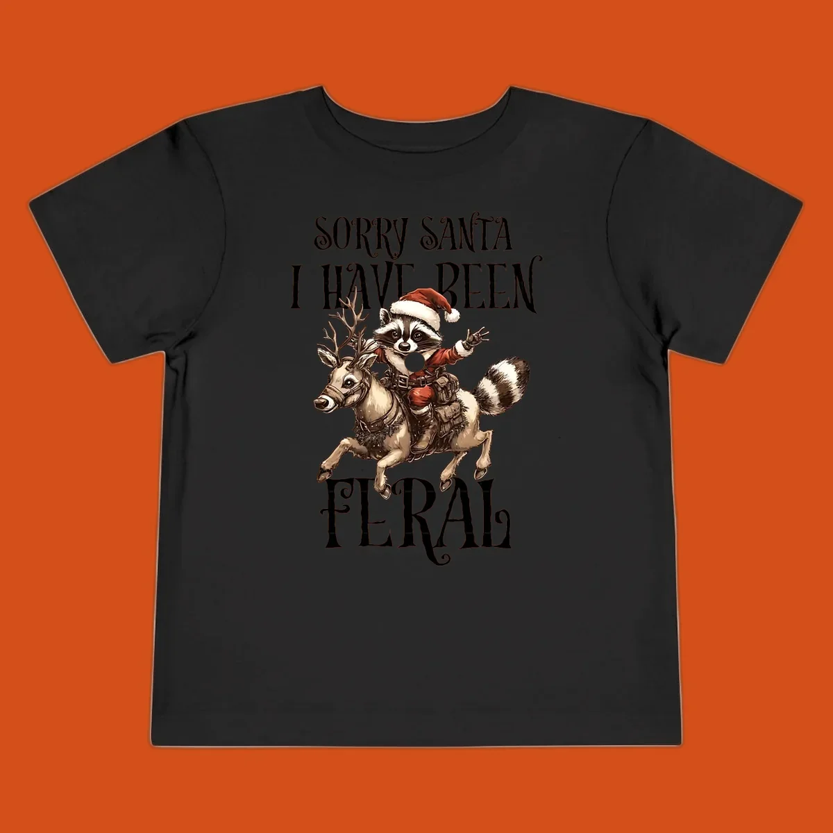 Feral raccoon in Santa hat riding reindeer, with text sorry santa i have been feral.