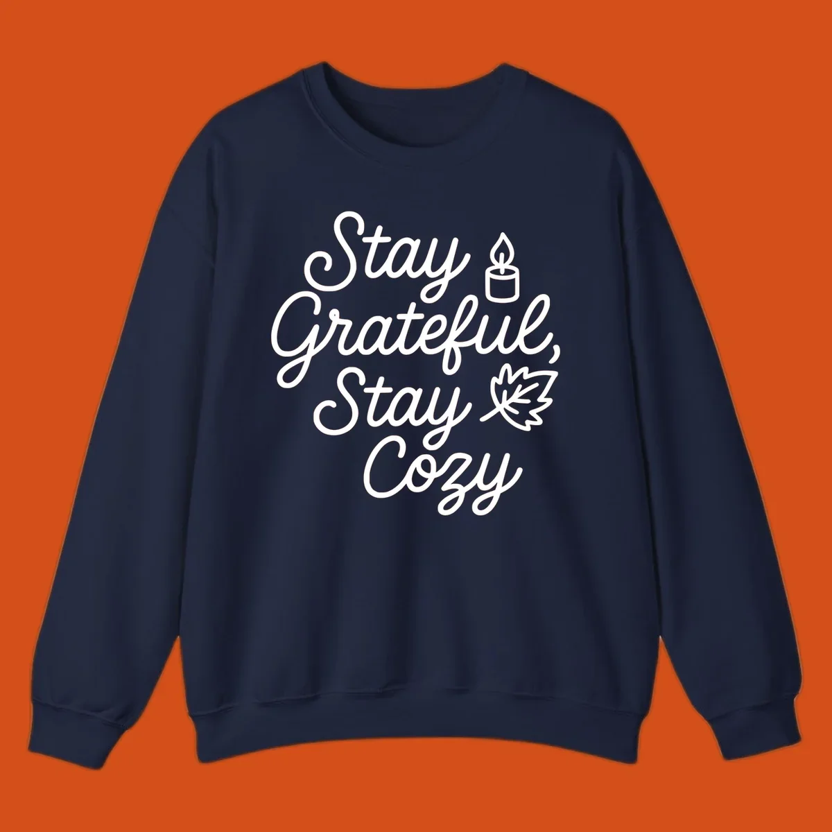 Text design with 'Stay Grateful, Stay Cozy' phrase, candle, and leaf for grateful-cozy-fall theme.