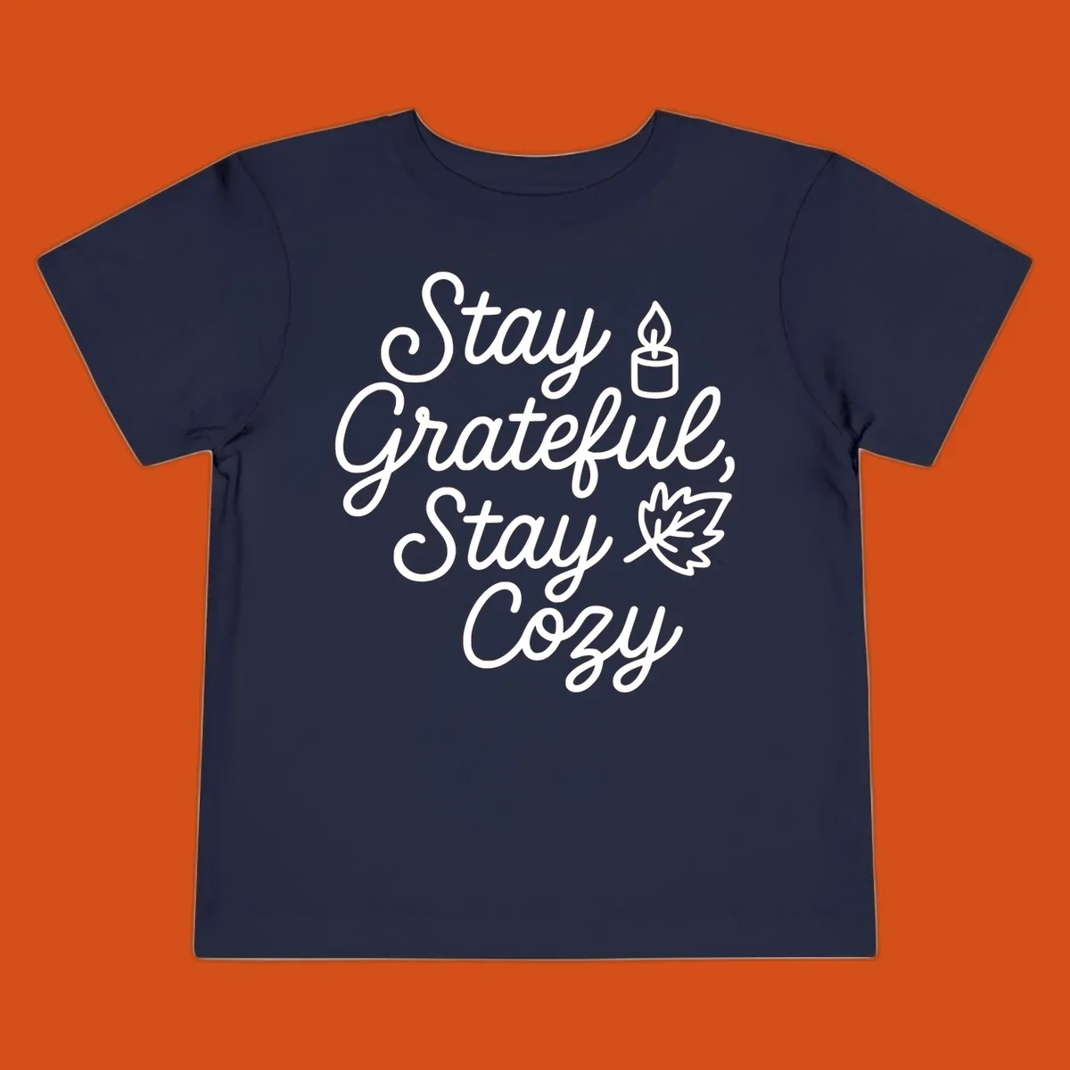 Text design with 'Stay Grateful, Stay Cozy' phrase, candle, and leaf for grateful-cozy-fall theme.