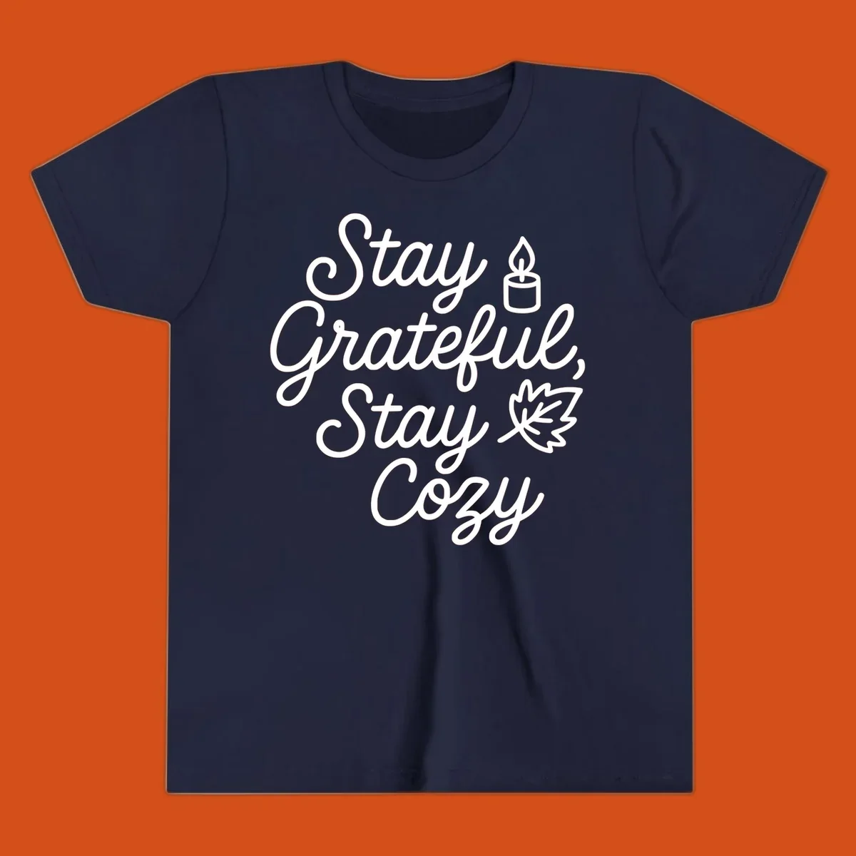 Text design with 'Stay Grateful, Stay Cozy' phrase, candle, and leaf for grateful-cozy-fall theme.