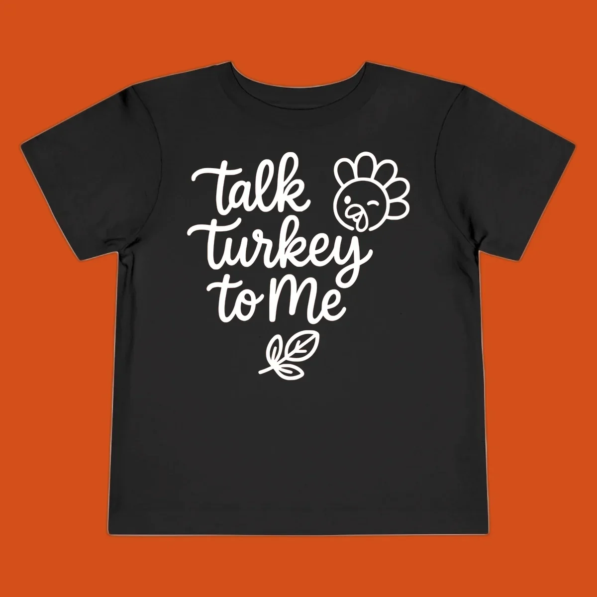 Talk Turkey To Me Thanksgiving phrase with cartoon turkey and leaf illustration.