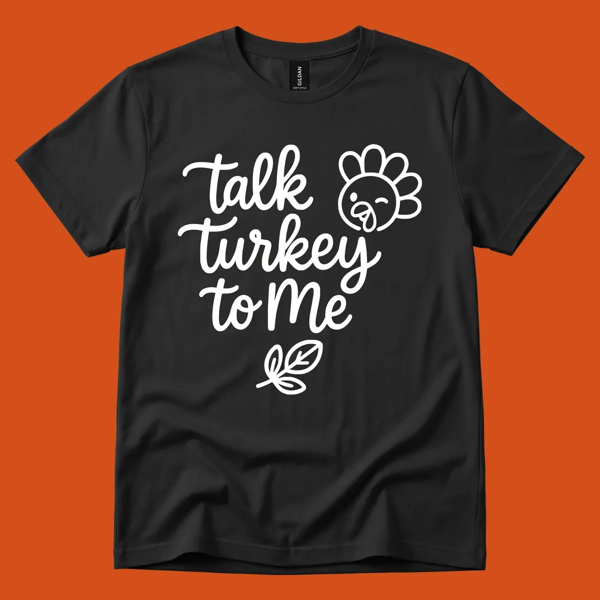 Talk Turkey To Me Thanksgiving phrase with cartoon turkey and leaf illustration.
