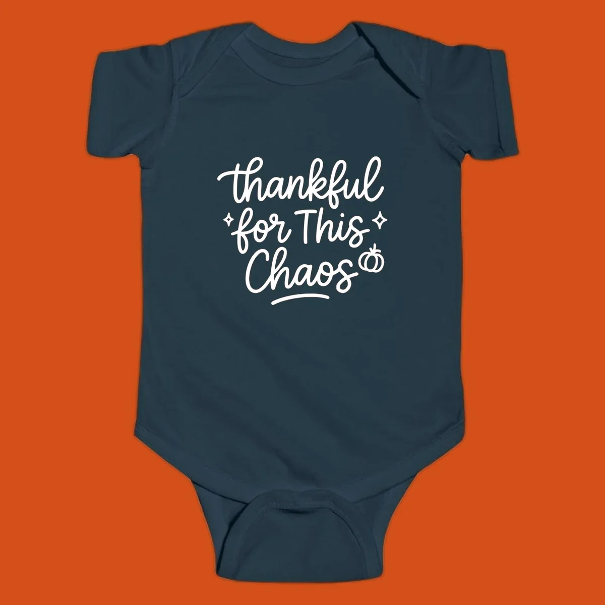 White script text 'thankful for This Chaos' with sparkles and a pumpkin on a black background.