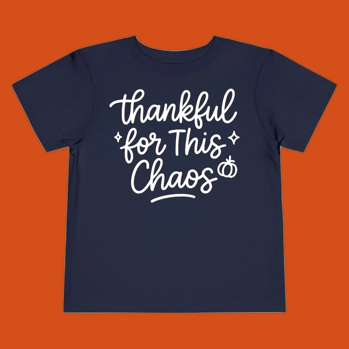 White script text 'thankful for This Chaos' with sparkles and a pumpkin on a black background.