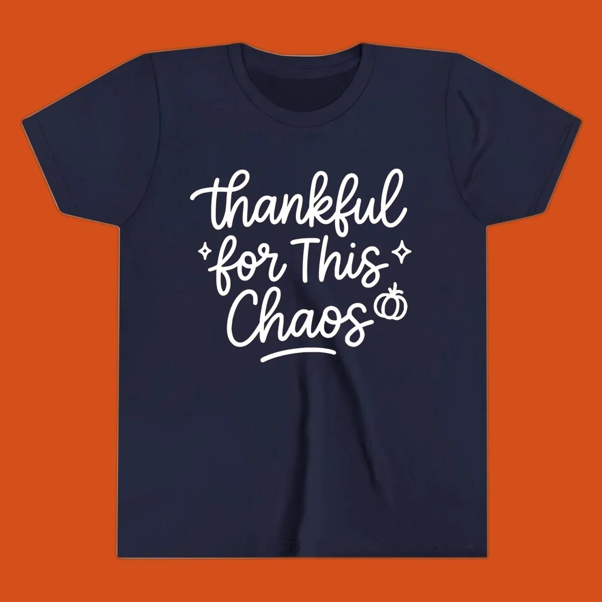 White script text 'thankful for This Chaos' with sparkles and a pumpkin on a black background.