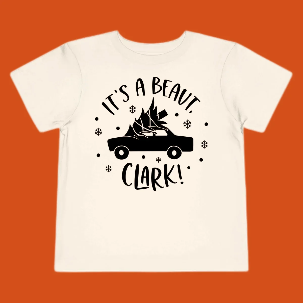White silhouette of a car with a Christmas tree on top, and text 'IT'S A BEAUT, CLARK!'