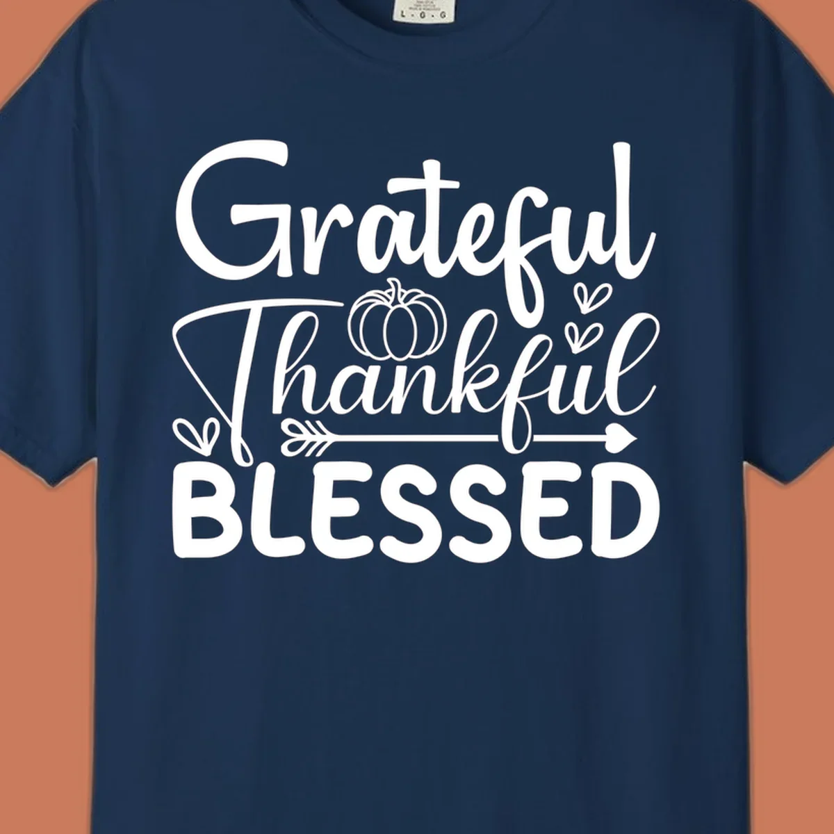 Grateful Thankful Blessed typography design with pumpkin, hearts, and arrow.