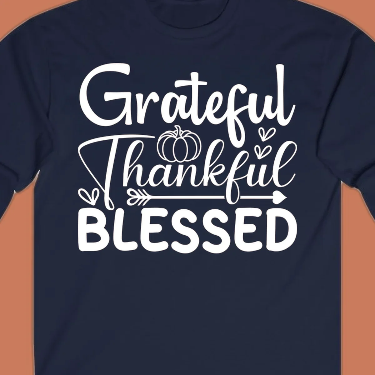 Grateful Thankful Blessed typography design with pumpkin, hearts, and arrow.