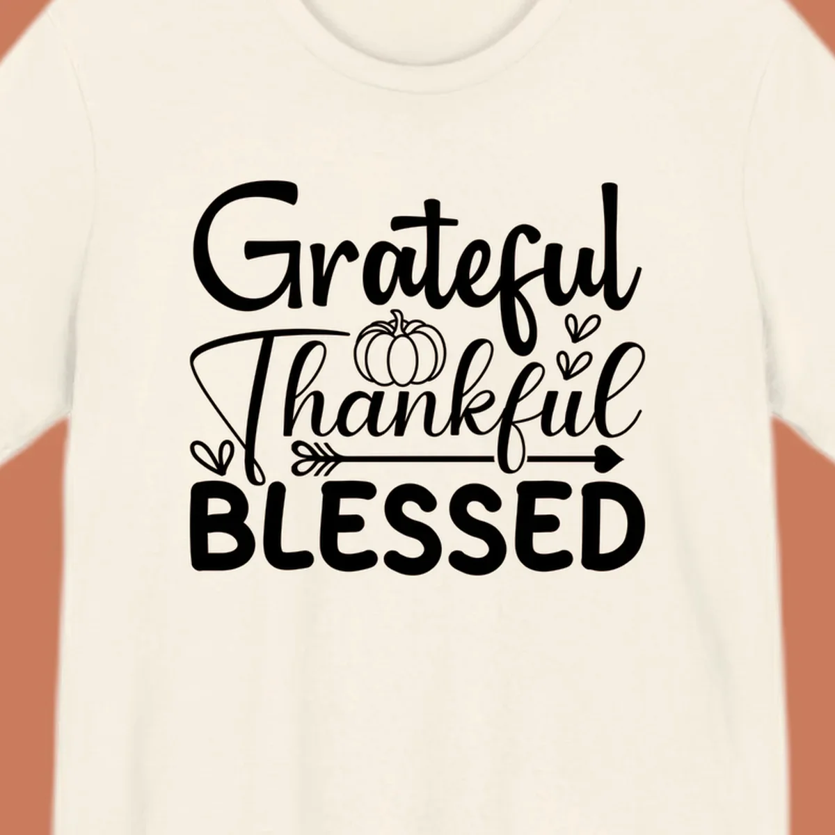 Grateful Thankful Blessed typography design with pumpkin, hearts, and arrow.