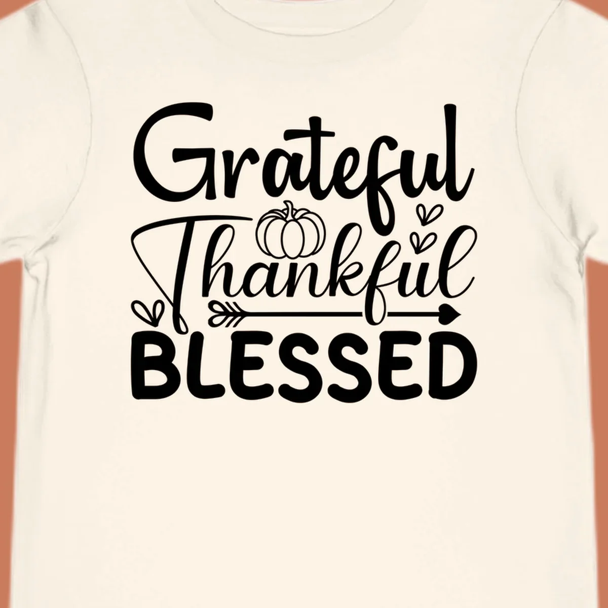 Grateful Thankful Blessed typography design with pumpkin, hearts, and arrow.