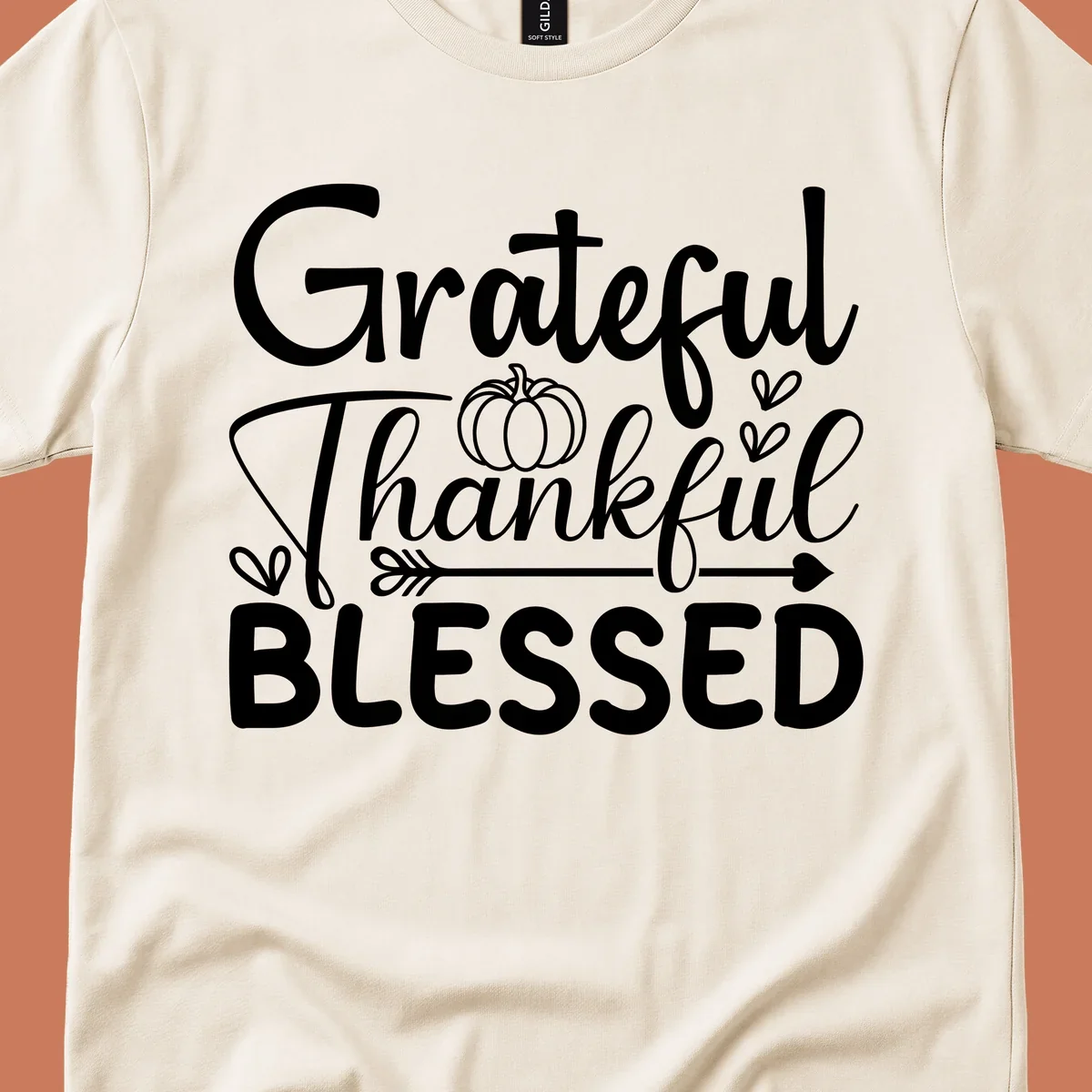 Grateful Thankful Blessed typography design with pumpkin, hearts, and arrow.
