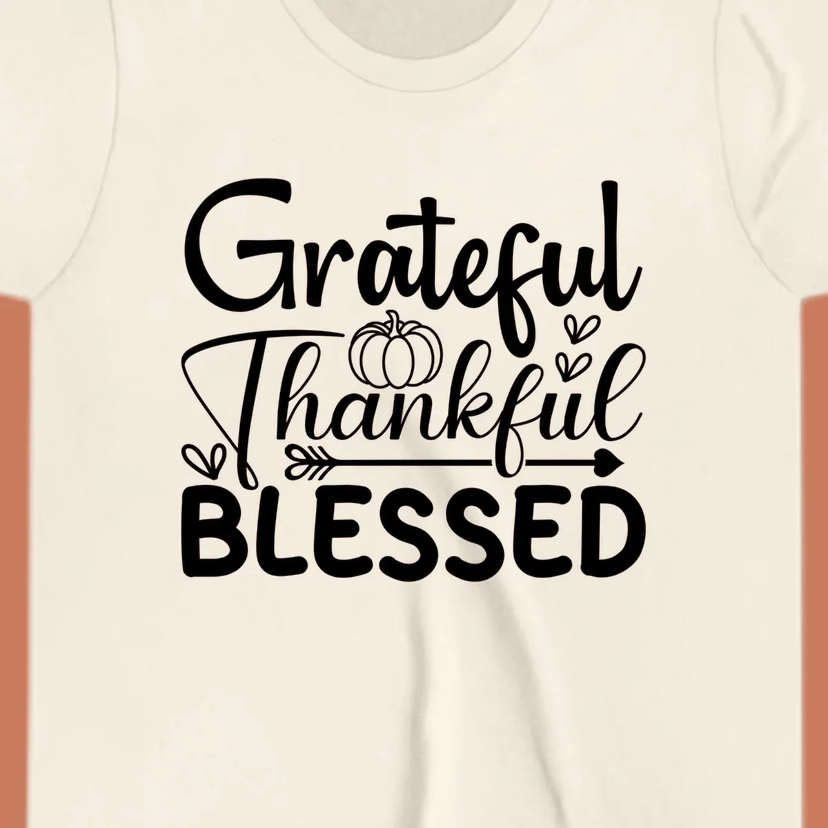 Grateful Thankful Blessed typography design with pumpkin, hearts, and arrow.